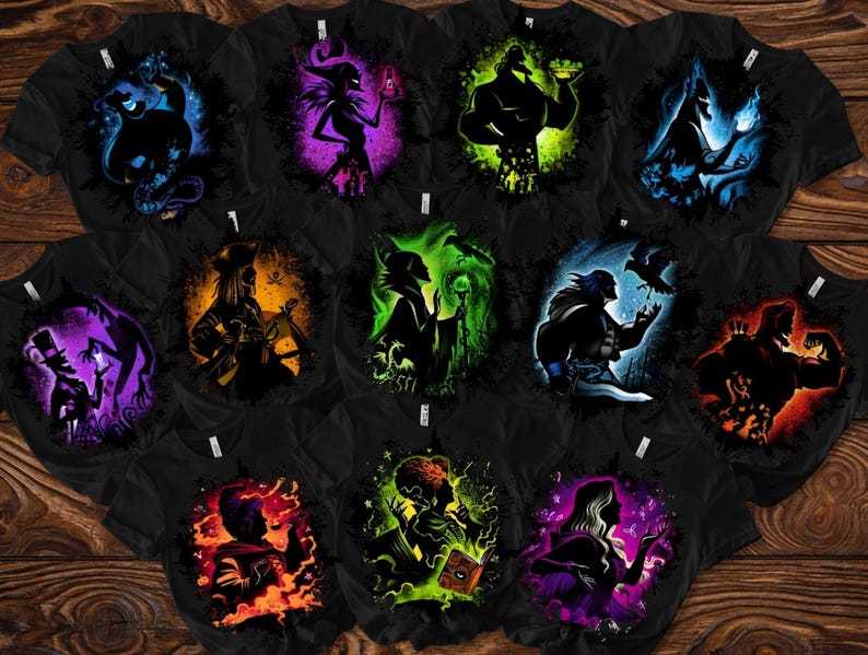 May include: A collection of black t-shirts featuring colorful silhouette designs of various characters. Each shirt showcases a different character in vibrant hues, including blue, purple, green, orange, and yellow, against a dark background. The shirts are arranged on a wooden surface.