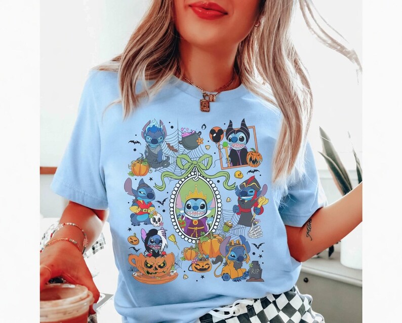 Może przedstawiać: Jasnoniebieska koszulka z halloweenową grafiką przedstawiającą postać z kresk&oacute;wki w r&oacute;żnych kostiumach, otoczoną dyniami i nietoperzami. Projekt jest wyśrodkowany na koszulce i zawiera ozdobną ramkę.