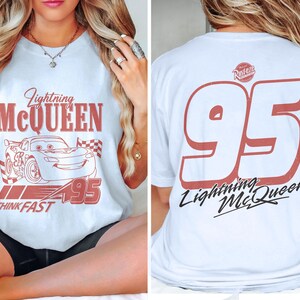 May include: White t-shirt featuring Lightning McQueen from the Cars movie. The front graphic includes the character's image, the number 95, and the text "Think Fast." The back displays a large number 95 and "Lightning McQueen."
