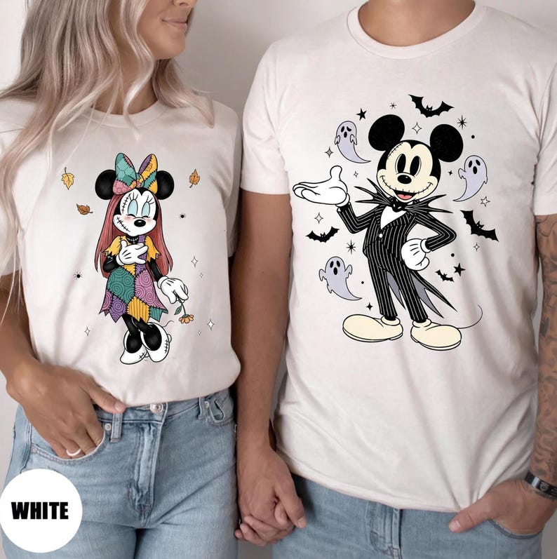 May include: White t-shirts featuring Halloween-themed Disney character designs. One shirt displays Minnie Mouse in a patchwork dress, the other shows Mickey Mouse as Jack Skellington. The word "WHITE" is printed on the bottom left.