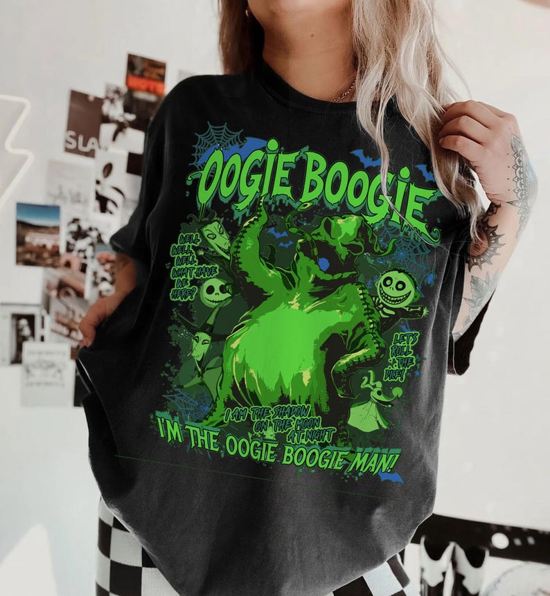 Op de afbeelding: Donkergrijs t-shirt met een groene afbeelding van Oogie Boogie uit The Nightmare Before Christmas. Het ontwerp bevat de tekst "Oogie Boogie" en "I'm the Oogie Boogie Man!" met andere personages.