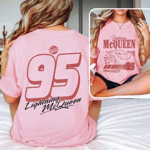 May include: Pink t-shirt featuring Lightning McQueen graphics. The front displays a graphic of the character and the text "Lightning McQueen" and "Think Fast". The back has a large "95" and the text "Lightning McQueen".