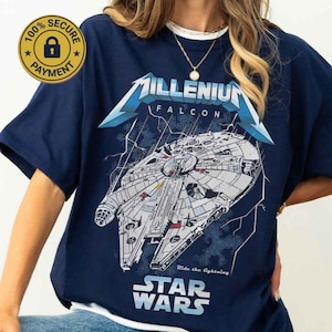 Op de afbeelding: Marineblauw T-shirt met een gedetailleerde illustratie van het ruimteschip Millennium Falcon uit Star Wars. Het shirt bevat de tekst "Millenium Falcon" en "Star Wars", met de zin "Ride the lightning" eronder.