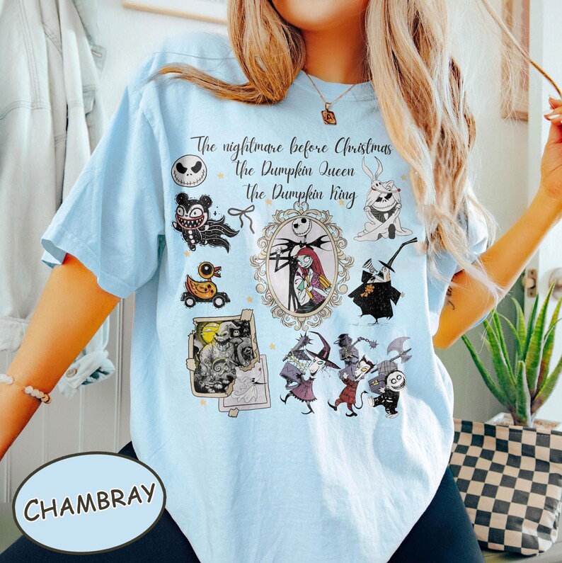 Pu&ograve; includere: T-shirt azzurra con personaggi e testo da "Nightmare Before Christmas". Il design include Jack Skellington, Sally e altri personaggi. La maglietta ha maniche corte e girocollo.