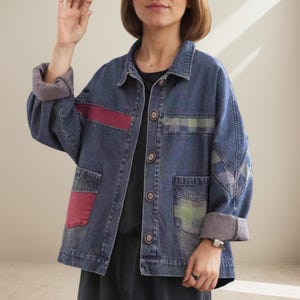 以下が含まれることがあります： 赤と緑のパッチワークが施されたブルーデニムジャケット。 ジャケットはボタン留め、2つのフロントポケット、ロールアップスリーブが特徴です。 ゆったりとしたフィット感で、クラシックな襟が付いています。