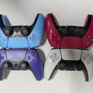 May include: Four wireless game controllers arranged in a square. The top left is light blue, the top right is dark red, the bottom left is purple, and the bottom right is white. Each controller features black analogue sticks, a central touchpad, and buttons.
