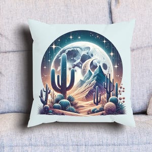 Puede incluir: Un coj&iacute;n decorativo con un dise&ntilde;o de paisaje des&eacute;rtico. La imagen presenta una luna llena, cactus y monta&ntilde;as en un marco circular. La paleta de colores incluye azules, naranjas y morados, creando una est&eacute;tica art&iacute;stica y caprichosa. El coj&iacute;n es cuadrado y descansa sobre un sof&aacute; gris claro.