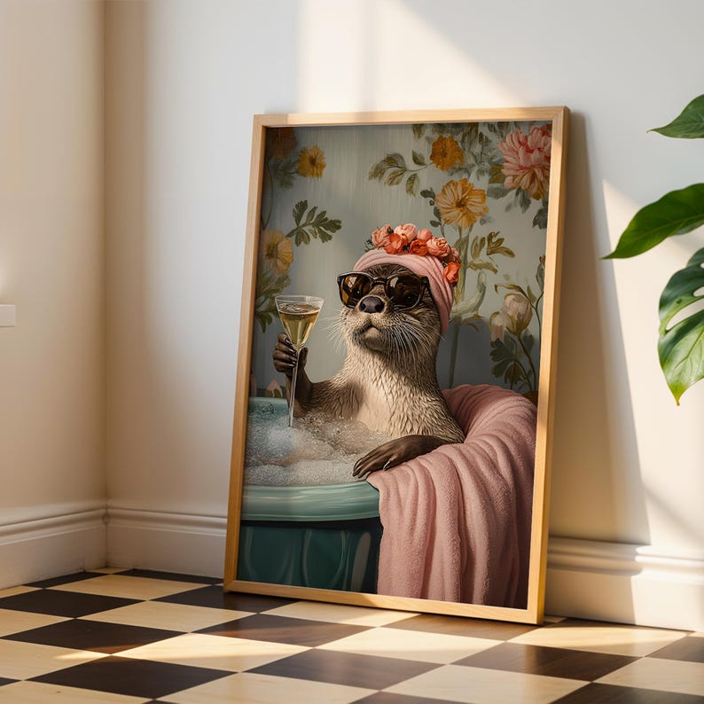 May include: Framed art print featuring an otter in a bathtub, wearing sunglasses and a pink turban with flowers. The otter holds a glass of champagne. The background has a floral wallpaper design. The print is in a wooden frame.