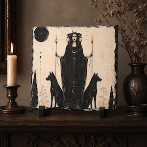 May include: A square slate plaque featuring a detailed illustration of a three-headed figure in a long black robe holding two torches, flanked by two black dogs. The artwork includes celestial moon symbols, stars, and thin vertical lines.