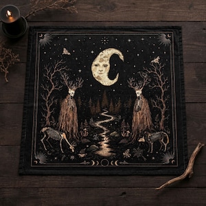 May include: Black square tapestry depicting a mystical forest scene. It features a crescent moon with a face, skeletal figures with antlers, and a winding river. The design includes stars, trees, and animal skeletons, creating a dark, gothic aesthetic.