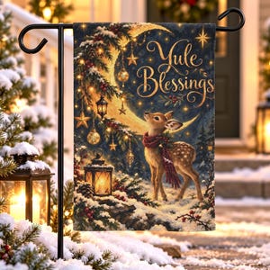 Puede incluir: Una bandera de jardín rectangular que muestra un cervatillo con una bufanda roja en un bosque nevado. La escena incluye una gran luna creciente, linternas colgantes y ramas de pino. El texto Yule Blessings aparece en letras doradas arriba.