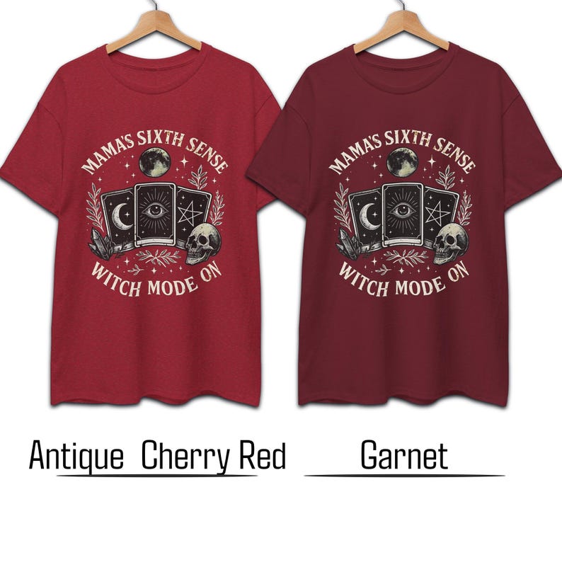 K&ouml;nnte beinhalten: Zwei rote T-Shirts mit einem grafischen Design mit Tarotkarten, einem Totenkopf und dem Text "MAMA'S SIXTH SENSE WITCH MODE ON." Die Shirts sind in Antik-Kirschrot und Granat gehalten.
