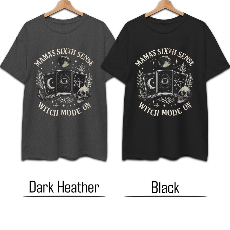 K&ouml;nnte beinhalten: Zwei T-Shirts, eines dunkelgrau und eines schwarz, werden gezeigt. Jedes Shirt hat eine kreisf&ouml;rmige Grafik mit dem Text "MAMA'S SIXTH SENSE" und "WITCH MODE ON". Die Grafik enth&auml;lt Tarotkarten, einen Totenkopf und Himmelselemente.