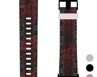 May include: Black and red floral patterned watch band. The band features a repeating pattern of red roses on a black background with a decorative lace design. The band has a black buckle and a white strap.