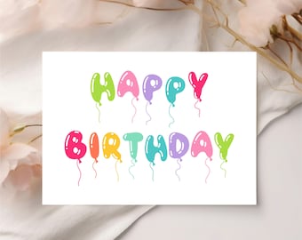 Può includere: Un biglietto di auguri bianco con la scritta "HAPPY BIRTHAY" in lettere colorate a forma di palloncino. I palloncini sono in tonalità di verde, rosa, viola, blu, arancione e giallo. Il biglietto è ambientato su uno sfondo bianco con accenti floreali.
