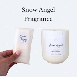 Op de afbeelding: Een witte, geribbelde kaars en een verpakte zeep. De kaars heeft een label met de tekst "Snow Angel" en "Handmade Natural Soy Wax". De zeep is gelabeld "Snow Fairy".