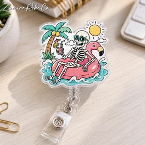 Peut inclure: Un enrouleur de badge en acrylique transparent avec une illustration imprimée d'un squelette portant des lunettes de soleil bleu sarcelle, se relaxant dans une bouée flamant rose sur l'eau bleue. Un soleil jaune et un palmier sont visibles.