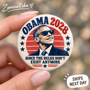 May include: A round pinback button featuring a graphic illustration of Barack Obama wearing sunglasses. The design includes the text OBAMA 2028 and SINCE THE RULES DON'T EXIST ANYMORE, set against a background of red horizontal stripes and blue stars.