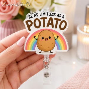 May include: An acrylic badge reel featuring a cartoon potato character with a smiling face and raised arms. Behind the potato is a colorful rainbow. The text above reads BE AS LIMITLESS AS A POTATO in brown letters. The reel has a clear plastic clip.
