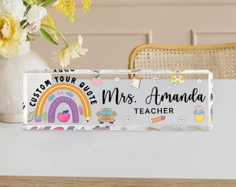 May include: A rectangular acrylic block with a colourful design for a teacher. The block features a rainbow, school bus, and the text "Mrs. Amanda Teacher". The words "Custom Your Quote" are also included in the design.