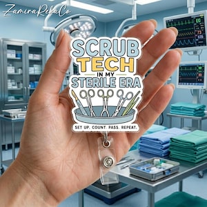 Op de afbeelding: Een badge reel met de tekst "SCRUB TECH IN MY STERILE ERA" en een illustratie van chirurgische instrumenten. De badge reel wordt in een hand gehouden, met een medische omgeving op de achtergrond. De tekst "SET UP. COUNT. PASS. REPEAT." is ook aanwezig.