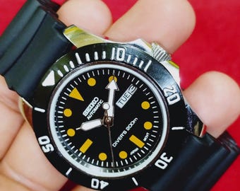 vintage Montre-bracelet automatique japonaise Seiko 5, date du jour, cadran noir, lunette tournante, 40 mm.