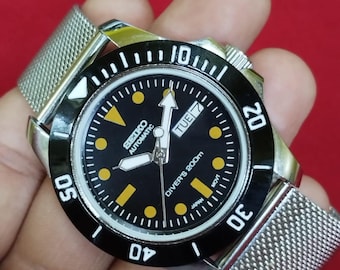 vintage Montre-bracelet automatique japonaise Seiko 5, date du jour, cadran noir, lunette tournante, 40 mm.