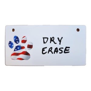 May include: White dry erase board with a red, white, and blue paw print and the words "DRY ERASE" written in black marker.