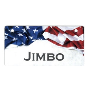 May include: A white rectangular tag with a red, white, and blue American flag draped over the top. The tag has the word "JIMBO" printed in black letters.