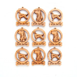 May include: Nine wooden Irish Setter ornaments. Each ornament features a laser-cut dog design within a circular frame. The words "Irish Setter" are laser-cut on a bone-shaped tag below each ornament. The ornaments are light brown.