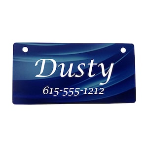 May include: Blue pet ID tag with white text that reads "Dusty" and "615-555-1212".