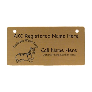 May include: A gold-colored metal tag with rounded corners and two holes. The tag features a black silhouette of a Pembroke Welsh Corgi and the text "AKC Registered Name Here", "Call Name Here", and "Optional Phone Number Here".