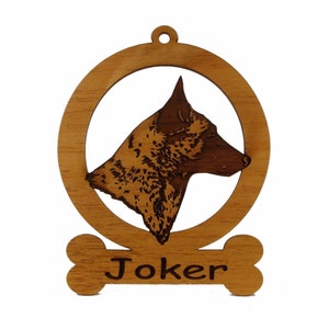 May include: Wooden Christmas ornament featuring a brown and black dog head silhouette with the name "Joker" engraved on a bone-shaped tag.