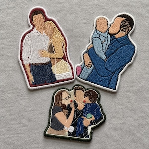 May include: Three embroidered fabric patches featuring faceless figures. One patch shows a couple embracing, another depicts a person holding a baby, and the third shows a family of three with a child holding a small green object.
