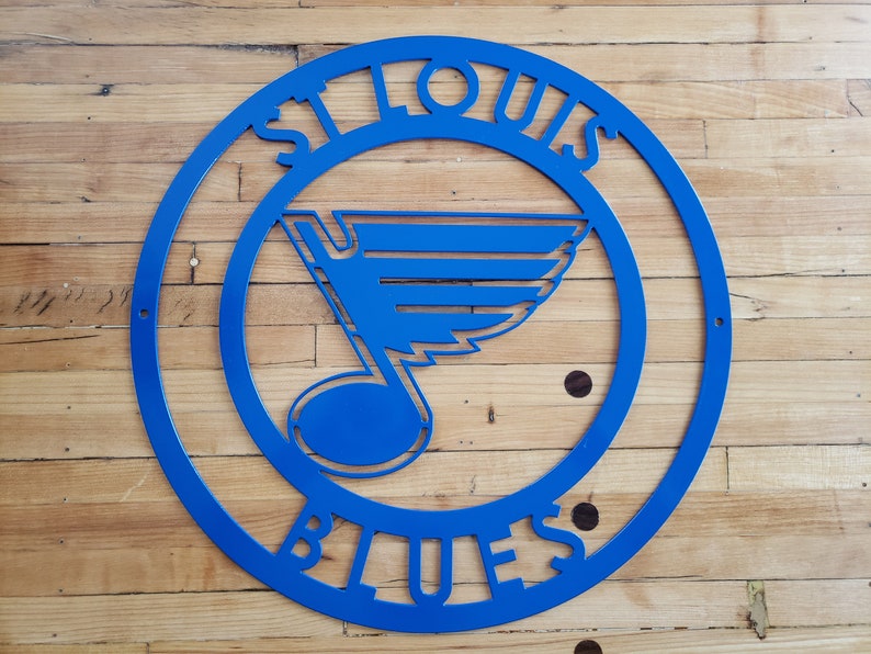 May include: Blue metal St. Louis Blues logo with a note and wing design. The logo is in a circle with the words "St. Louis Blues" around the outside.