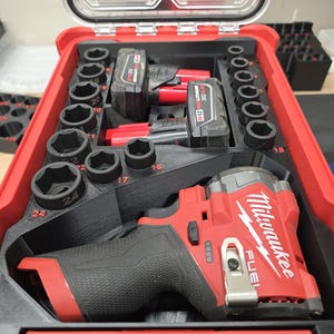 May include: A red and black Milwaukee FUEL impact wrench kit in a red case. The kit includes a wrench, sockets, and two M12 XC 4.0 Lithium batteries. The case is open, revealing the tools neatly organized.