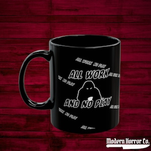 May include: Black coffee mug with a white silhouette of a person and the text "All work and no play" repeated around the mug.