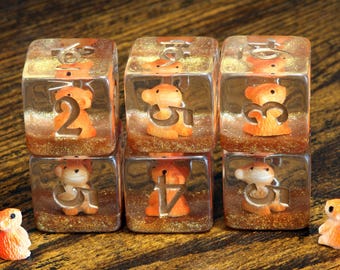 Hamster D6 Dice – transparant met kleine hamster aan de binnenkant op een gouden laag