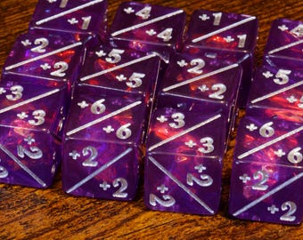 May include: A collection of purple dice with white numbering and diagonal lines. The dice are arranged in rows and columns, with numbers from 1 to 6 visible on the faces. The dice have a translucent, marbled appearance.