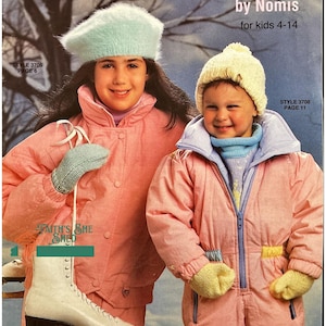 May include: Two children wearing pink snowsuits and knit hats. The girl on the left is holding a pair of white ice skates. The girl on the right is wearing a yellow knit hat. The text on the cover reads "Kid's Hats and 2-Needle Mittens by Nomis for kids 4-14".