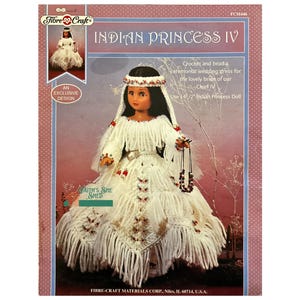 May include: A crochet pattern for an Indian Princess doll, featuring a white beaded dress with fringe and a beaded necklace. The pattern is for a 14 1/2 inch doll and is titled "Indian Princess IV".