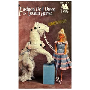 Può includere: Schema di uncinetto per un abito da bambola e un cavallo da sogno. Il modello è di Annie's Attic e non è rimborsabile. Il modello mostra un cavallo all'uncinetto bianco con una sella rosa e una bambola che indossa un abito a righe blu e rosa.