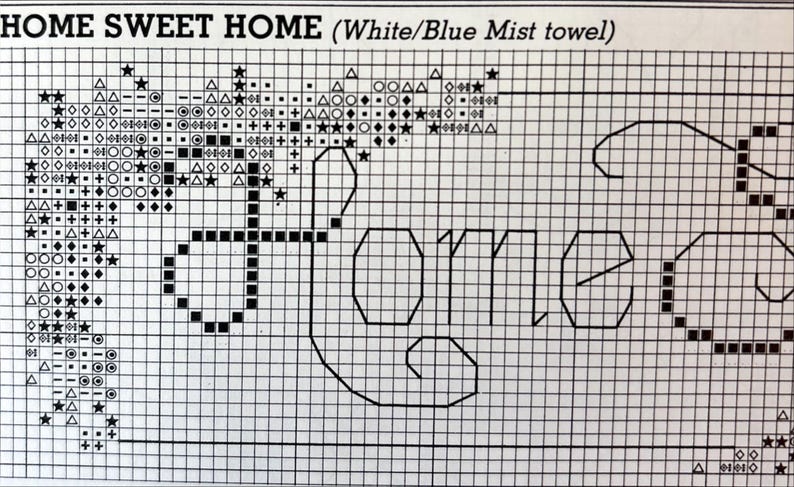 May include: Cross-stitch pattern with the words "HOME SWEET HOME" in a block letter font. The design includes decorative elements like stars and geometric shapes. The text "(White/Blue Mist towel)" is above the main text.