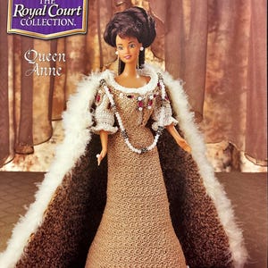 May include: A crocheted doll wearing a brown gown with a white fur trim. The doll has brown hair and brown eyes. The doll is wearing a pearl necklace and a crown. The doll is labeled "The Royal Court Collection. Queen Anne."