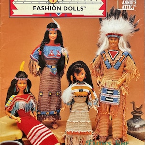 May include: Crochet pattern for Native American fashion dolls. The pattern includes four dolls: a woman with long black hair wearing a brown and blue beaded dress, a man wearing a brown and blue beaded shirt and pants, and two women wearing brown and white beaded dresses. The pattern is from Annie's Attic.