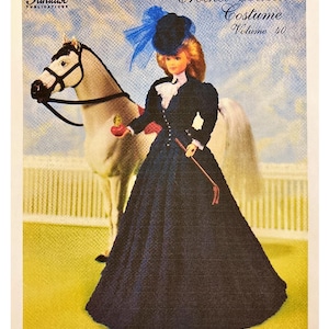 May include: A vintage crochet pattern cover featuring a doll in a dark blue riding costume with a matching hat and a riding crop. A crochet horse stands behind the doll. The text reads "Crochet Collector Costume Volume 40" and "1894 Riding Costume".