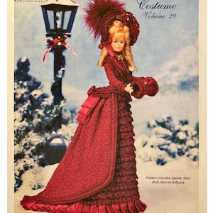 May include: A doll in a burgundy crochet winter carriage costume, including a jacket, skirt, muff, bonnet, and boots. The image is from a "Crochet Collector Costume" pattern, volume 29, published by Paradise Publications. The pattern is for an 1875 winter carriage costume.