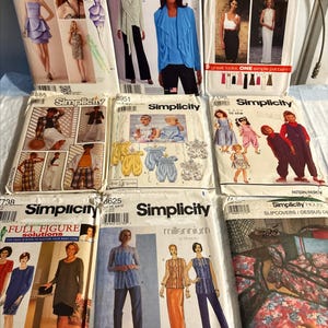 May include: A collection of Simplicity sewing patterns featuring various designs for dresses, robes, and other garments. The patterns showcase different styles, including options for full figures and baby clothes. The covers display images of the finished products.
