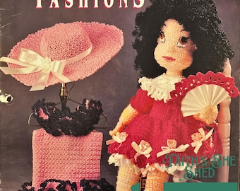 May include: A crochet doll pattern for a doll wearing a pink dress and a hat. The pattern is from Monique & Her Fashions and is titled "Annie's Attic".