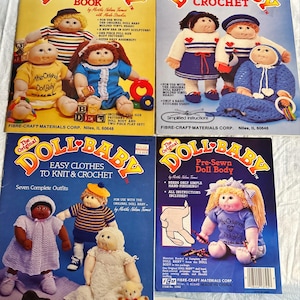 May include: Four vintage "Doll Baby" pattern books. The covers feature illustrations of dolls in various outfits, including crochet and knit designs. The books are from Fibre-Craft Materials Corp.